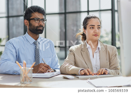Smart business people working together with laptop while talking in the coworking place. Smart business people working together with laptop while talking in the coworking place. 108569339