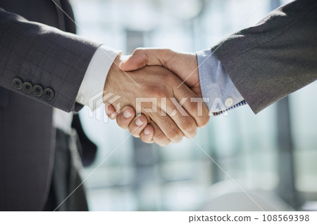 handshake in the office of two businessmen at the table handshake in the office of two businessmen at the table 108569398
