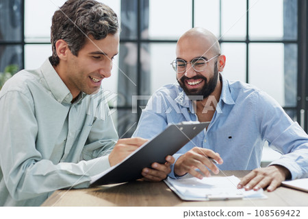 Startup partners discussing project at laptop, watching video presentation Startup partners discussing project at laptop, watching video presentation 108569422