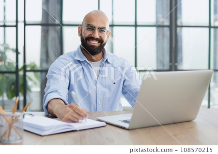 Businessman working on the table with laptop in a new office Businessman working on the table with laptop in a new office 108570215