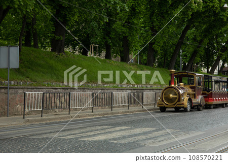 Tram on road, roadside with trees outdoors 108570221