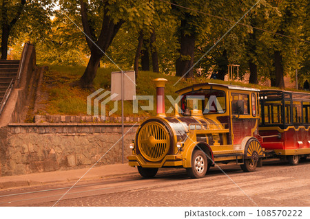 Tram on road, roadside with trees outdoors Tram on road, roadside with trees outdoors 108570222