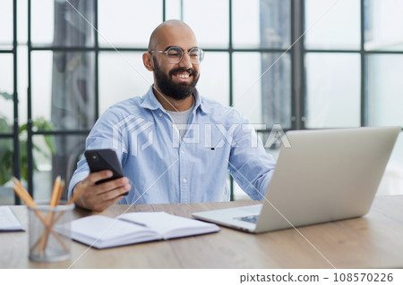 Businessman working on the table with laptop in a new office Businessman working on the table with laptop in a new office 108570226
