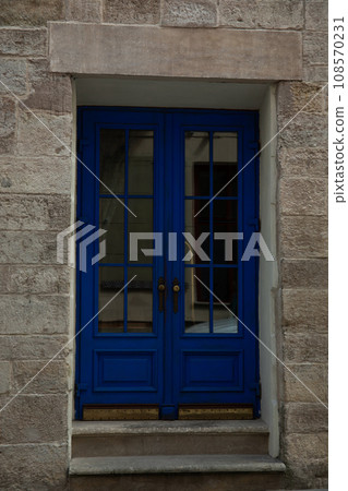 Brick building facade, steps and blue doors outdoors 108570231