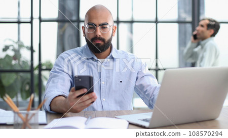 Businessman working on the table with laptop in a new office Businessman working on the table with laptop in a new office 108570294