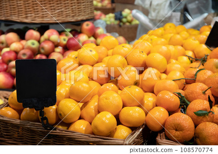 Tangerines and apples in wicker baskets in supermarket Tangerines and apples in wicker baskets in supermarket 108570774