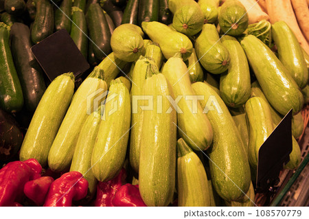 Zucchini and peppers on counter in supermarket, close up Zucchini and peppers on counter in supermarket, close up 108570779