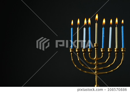 Hanukkiah with nine candles on black background, space for text Hanukkiah with nine candles on black background, space for text 108570886