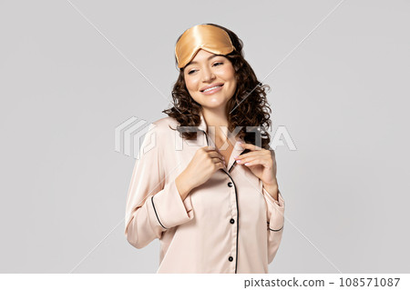 Beautiful girl in a sleeping mask and pajamas. 108571087