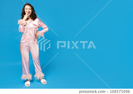 Girl in pink pajamas on a blue background. Girl in pink pajamas on a blue background. 108571098