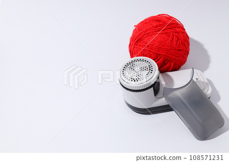 A machine for shaving fabric on clothes, on a light background. A machine for shaving fabric on clothes, on a light background. 108571231