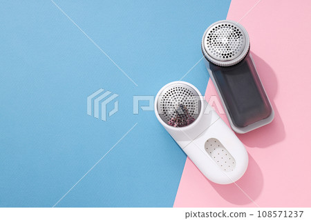 A machine for shaving fabric on clothes, on a blue background. A machine for shaving fabric on clothes, on a blue background. 108571237
