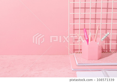 Notepads and pencils on pink background, space for text 108571339
