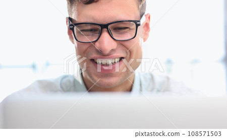 Shot of a young businessman using a laptop in a modern office 108571503