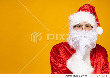 Santa Claus shows the gesture "hush", "shhh". 108571651