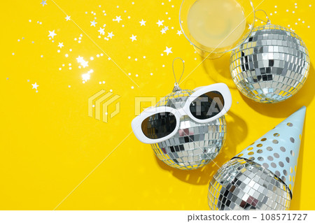 Disco balls with glasses on a yellow background Disco balls with glasses on a yellow background 108571727
