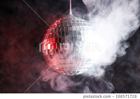 Disco ball in smoke on a dark background Disco ball in smoke on a dark background 108571728