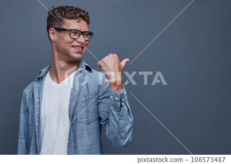 A man on a gray background shows aside A man on a gray background shows aside 108573487