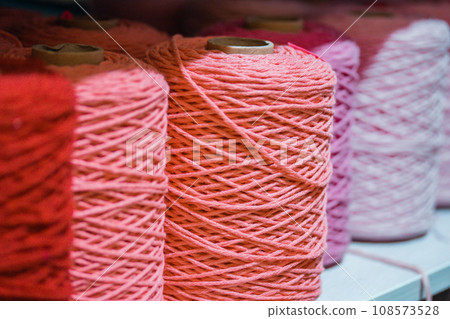 Group of pink thread spools. Colorful wool balls. Variety of knitting yarns. Coils and spools of colored thread, fabric cotton thread. Pinky bobbins in a raw. Sewing hand made hobby. Fashion industy. 108573528