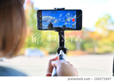 一位女士在車內用智慧型手機拍照,直播秋葉 一位女士在車內用智慧型手機拍照,直播秋葉 108573847