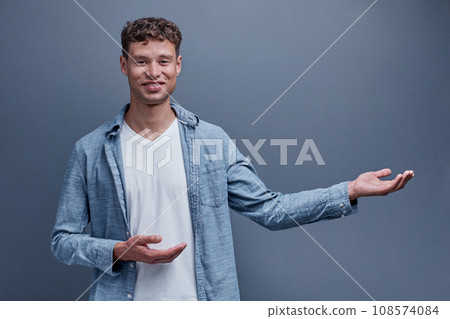A man on a gray background shows aside A man on a gray background shows aside 108574084