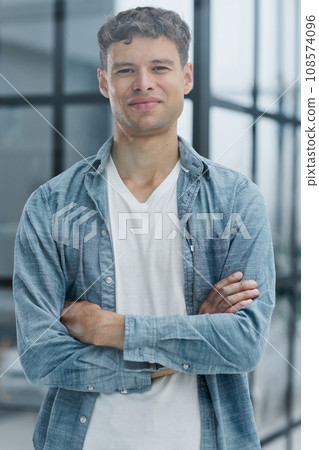 Portrait of smiling mid adult businessman standing at corporate office 108574096