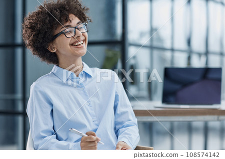 Happy female designer standing in office 108574142