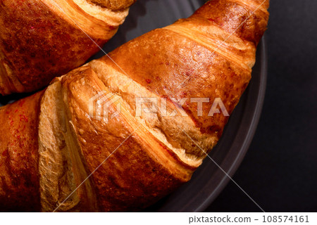 Fresh croissants on a black background closeup. Top view Fresh croissants on a black background closeup. Top view 108574161