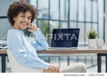 Happy female designer standing in office 108574167