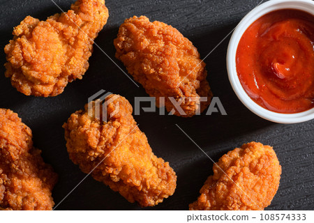 Fried chicken strips breaded with ketchup on the table. View from above 108574333