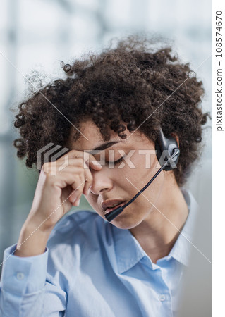 a girl in a modern office working in a call center concentrates on explaining the procedure 108574670