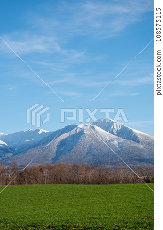 Late autumn green fields and snow-capped mountains - Tokachidake Mountain Range 108575115