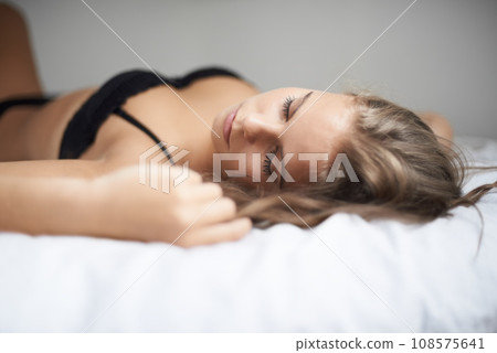 Lingerie, woman and bed with sleeping, rest and relax in a bedroom with underwear and calm. Sexy, fashion and confidence with nap at home on a blanket and sheets lying down with peace and bra Lingerie, woman and bed with sleeping, rest and relax in a bedroom with underwear and calm. Sexy, fashion and confidence with nap at home on a blanket and sheets lying down with peace and bra 108575641