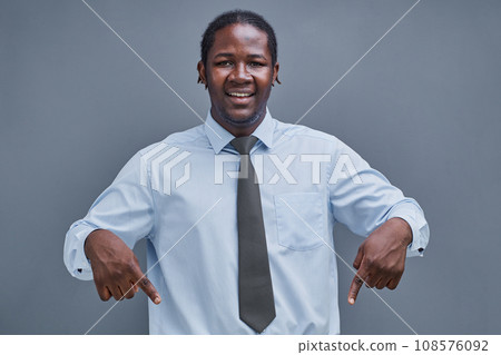 young african american man, surprised, points down with his hand young african american man, surprised, points down with his hand 108576092