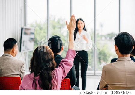A large group in a seminar classroom raises their hands, actively participating and engaged in the discussion. The audience has the answer in this dynamic conference setting. A large group in a seminar classroom raises their hands, actively participating and engaged in the discussion. The audience has the answer in this dynamic conference setting. 108576125