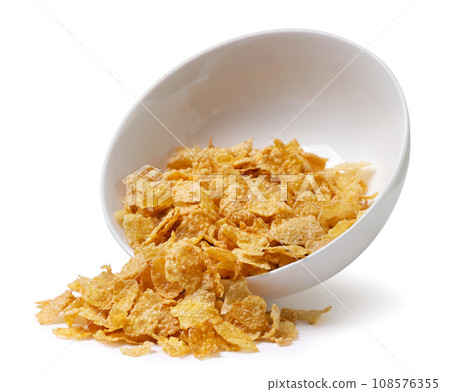 Corn flakes spilled out of a plate close-up on a white. Isolated 108576355