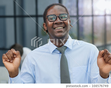 portrait of a man at his workplace at the table in front of the computer smiling portrait of a man at his workplace at the table in front of the computer smiling 108576749
