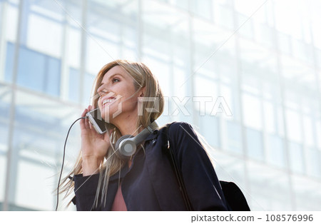 Phone call, business woman and talking in street, city or town with contact outdoors. Technology, thinking and happy female entrepreneur with 5g mobile smartphone for networking, chat and discussion. 108576996