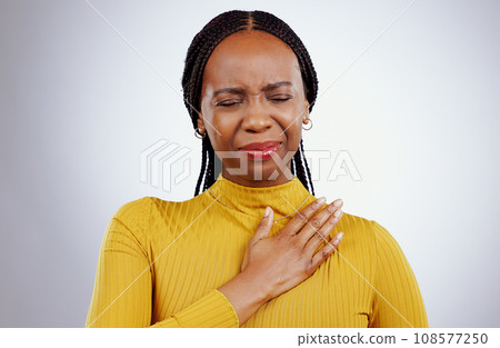 Heart pain, black woman and ache with stress, anxiety and problem from cardiology crisis in studio. White background, African female person and heartburn with cardiac arrest and sick from grief 108577250