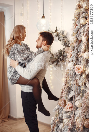 People in a Christman decorations. Man in a gray sweater. Family at home. 108577399