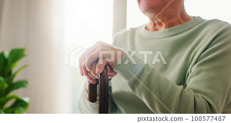 Hands, old person with disability and walking stick, closeup with wellness and retirement. Senior care, cane to help with balance and support, Parkinson disease or arthritis, sick and health issue Hands, old person with disability and walking stick, closeup with wellness and retirement. Senior care, cane to help with balance and support, Parkinson disease or arthritis, sick and health issue 108577487