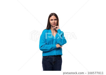 young confused caucasian woman with black hair dressed in a blue cardigan and jeans thought on a 108577811
