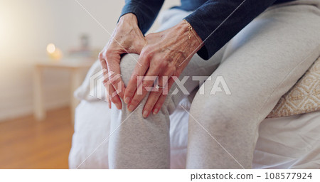 Hands, pain and closeup of senior woman in bedroom with injury, hurt or accident at nursing home. Sick, illness and zoom of elderly female person in retirement holding leg with sprain muscle at house Hands, pain and closeup of senior woman in bedroom with injury, hurt or accident at nursing home. Sick, illness and zoom of elderly female person in retirement holding leg with sprain muscle at house 108577924