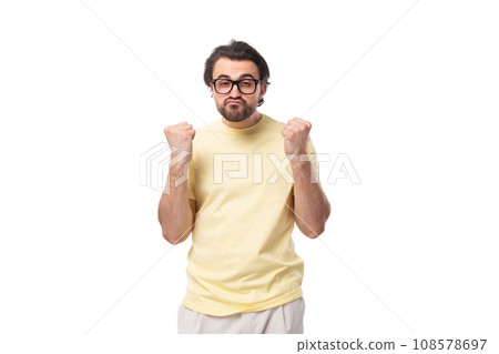 young brutal brunette man in a T-shirt on a white background with copy space young brutal brunette man in a T-shirt on a white background with copy space 108578697