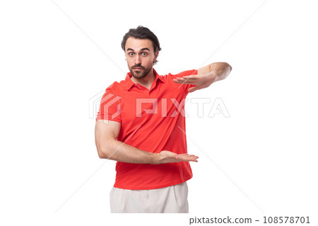 young brunette man with a beard is dressed in a red t-shirt with a mockup on a white background with young brunette man with a beard is dressed in a red t-shirt with a mockup on a white background with 108578701