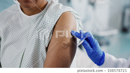 Doctor, hands and bandage on arm, vaccine and healthcare of patient in hospital. Nurse, plaster and injection of person closeup for medicine, virus immunity or help with treatment of injury in clinic Doctor, hands and bandage on arm, vaccine and healthcare of patient in hospital. Nurse, plaster and injection of person closeup for medicine, virus immunity or help with treatment of injury in clinic 108578721