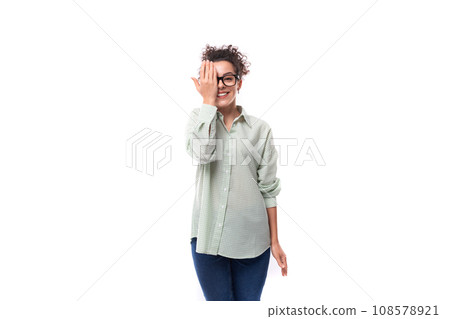 smiling young brunette curly woman dressed in a plaid shirt on a white background 108578921