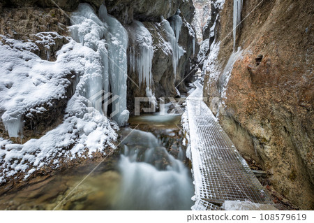 Winter landscape with a wild stream and waterfalls. Winter landscape with a wild stream and waterfalls. 108579619
