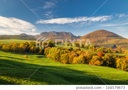View of autumn landscape with rocky mountains in the background. View of autumn landscape with rocky mountains in the background. 108579673