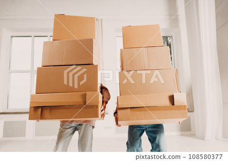 Happy young family couple close up man and woman moving with cardboard boxes to new estate home apartment. 108580377
